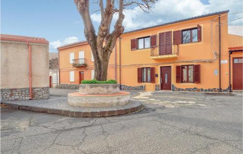 an orange building with a tree in the middle of a street at Casa Cubo in Flussio
