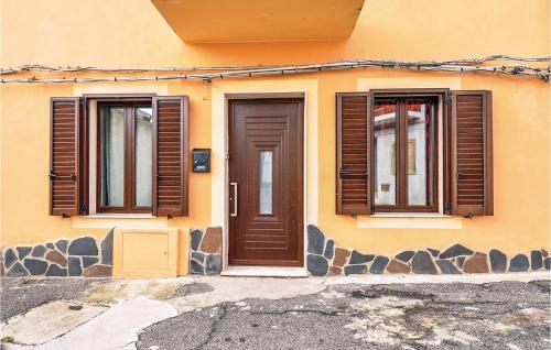une maison dotée de portes et de fenêtres marron dans l'établissement Casa Cubo, à Flussio