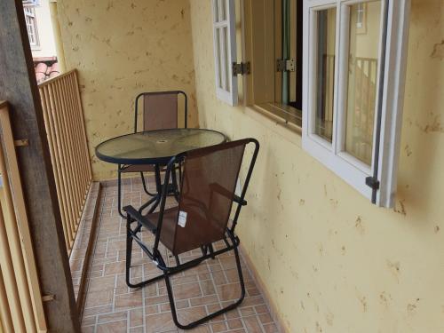 una mesa pequeña y sillas sentadas en un porche en Pousada As Relíquias de Minas, en Tiradentes