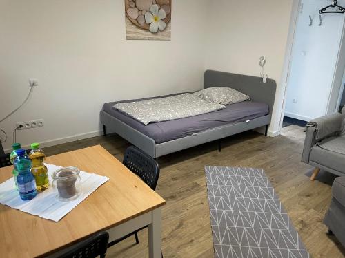 uma pequena sala de estar com uma cama e uma mesa em Gemütliche 1-Zimmer Wohnung mit eigenem Eingang em Wesseling