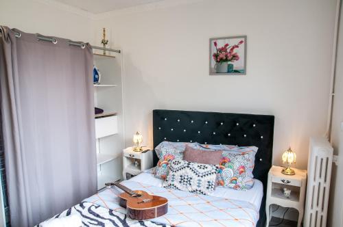 sypialnia z łóżkiem z czarnym zagłówkiem i poduszkami w obiekcie Flozed w Beauvais