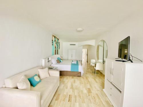 a white room with a bed and a couch at Cyan Cancun Resort & Spa in Cancún