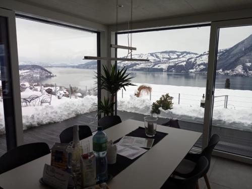 a dining room with a table and a large window at Moderne Unterkunft mit Panoramablick auf Thunersee in Krattigen