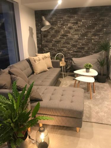 a living room with a couch and a table at Moderne Unterkunft mit Panoramablick auf Thunersee in Krattigen