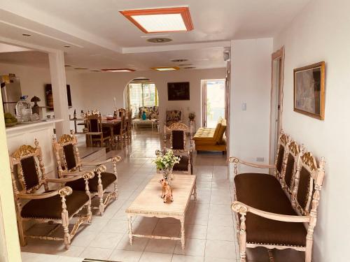 une chambre avec des chaises et une table fleurie. dans l'établissement Casa Familiar María E, à Filandia