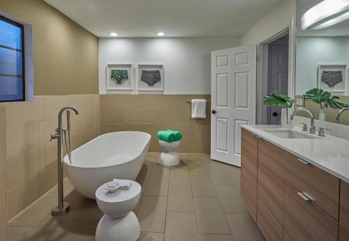 uma casa de banho com uma banheira, um WC e um lavatório. em Descanso Resort, A Men's Resort em Palm Springs