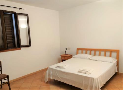 ein weißes Bett in einem Zimmer mit Fenster in der Unterkunft LE VILLETTE DI TERRANOVA in Lampedusa