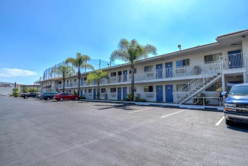 a parking lot in front of a building with palm trees at Motel 6-Rowland Heights, CA - Los Angeles - Pomona in Rowland Heights