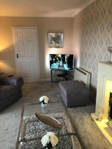 a living room with a coffee table and a tv at Skerrols in Broadford