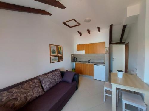 a living room with a couch and a kitchen at Apartments Božena in Pakoštane