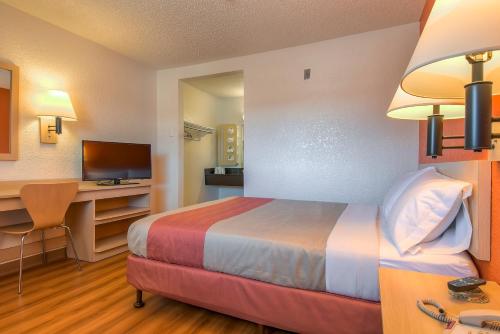 a hotel room with a bed and a desk with a computer at Motel 6-Rowland Heights, CA - Los Angeles - Pomona in Rowland Heights
