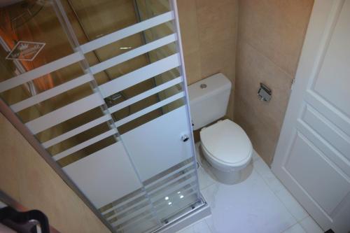a small bathroom with a toilet and a glass door at Apart SmartBox in Campana