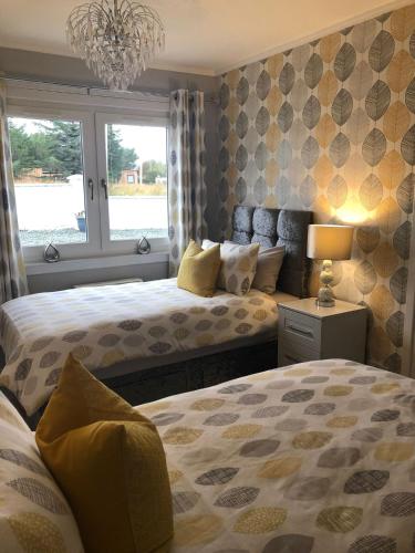 a bedroom with two beds and a window at Skerrols in Broadford