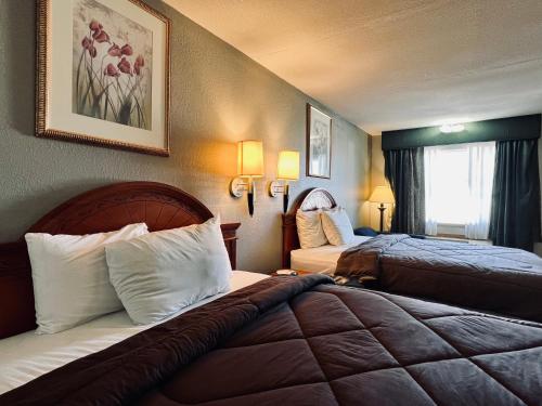 Habitación de hotel con 2 camas y ventana en Ozark Inn & Suites, en Ozark