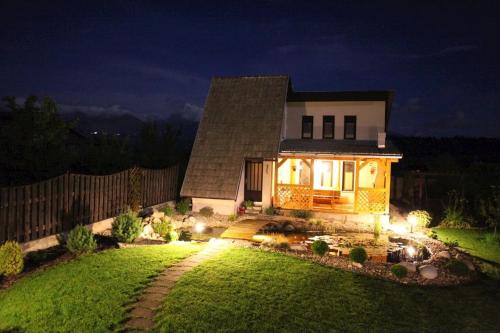 a house with lights in the yard at night at Apartmán Vika in Štrba