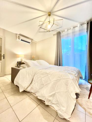 une chambre avec un grand lit blanc et une fenêtre dans l'établissement La Bulle de Champagne, à Champagne-au-Mont-dʼOr