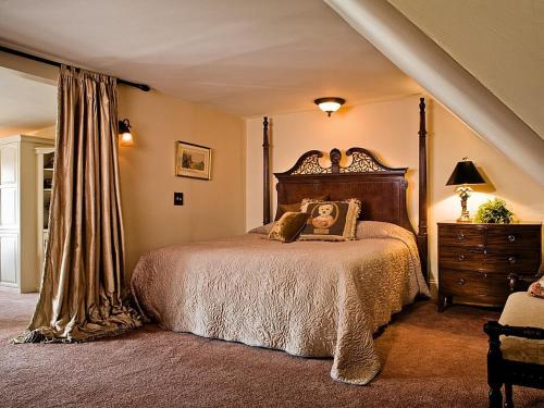 1 dormitorio con 1 cama grande y cabecero de madera en 1900 Inn on Montford, en Asheville