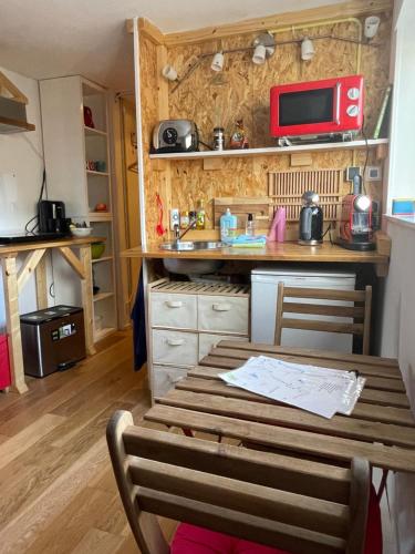 una pequeña cocina con mesa y microondas en Studio 7, en Hoogland