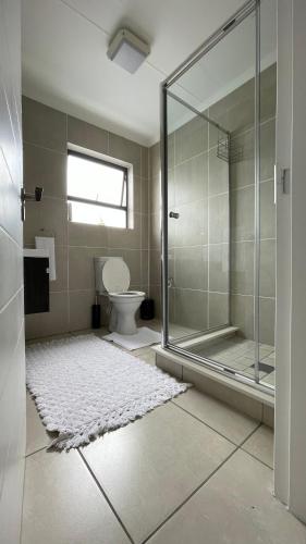 a bathroom with a glass shower and a toilet at 417 The Sandown in Cape Town