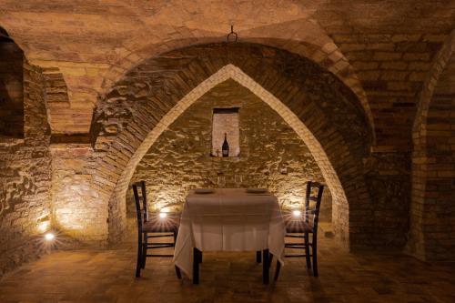 a dining room with a table in a stone wall at Castello di Petecciano B&B in Mosciano SantʼAngelo