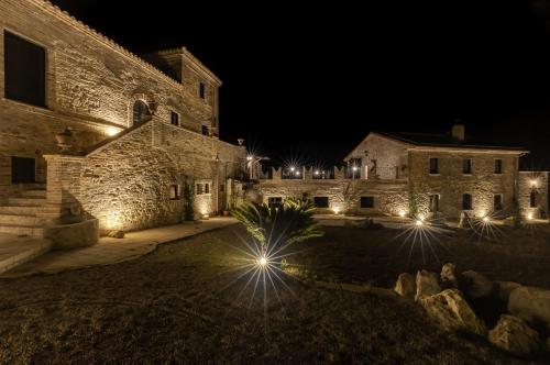 a stone building with lights in the night at Castello di Petecciano B&B in Mosciano SantʼAngelo