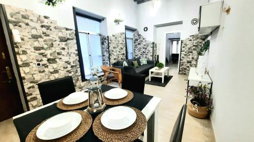 uma mesa de jantar numa sala de estar com uma parede de pedra em Apartamento Levante em Cádis