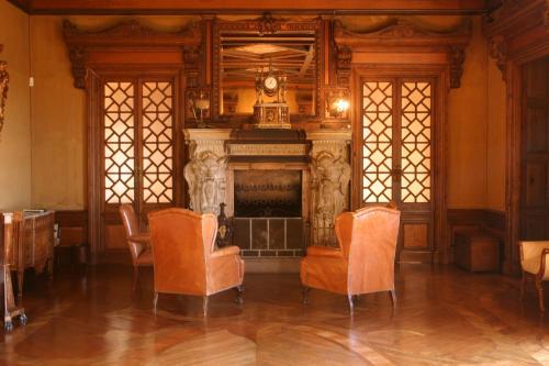 a living room with a fireplace and orange chairs at Parador Casa Da Insua in Penalva do Castelo