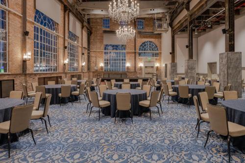 a banquet hall with tables and chairs and a chandelier at NOPSI Hotel New Orleans in New Orleans