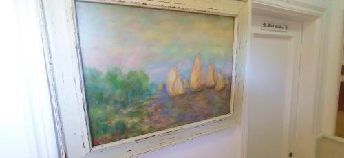 a painting hanging on a wall next to a window at Prau Riu Hotel Hyundai-Asturdai in Llanes