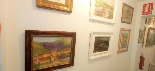 a group of paintings hanging on a wall at Prau Riu Hotel Hyundai-Asturdai in Llanes