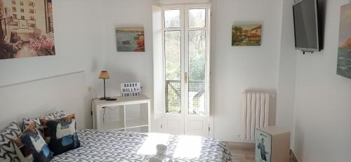 a white bedroom with a bed and a window at Prau Riu Hotel Hyundai-Asturdai in Llanes