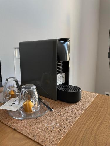 a coffee maker sitting on a table with two glasses at Lisbon Check-In Guesthouse in Lisbon