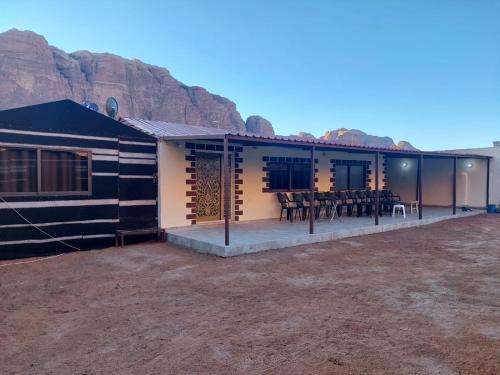 a house in the desert with mountains in the background at Wadi Rum Oryx Hostel & Tours in Wadi Rum