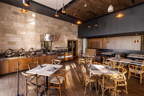 a restaurant with tables and chairs and a kitchen at TRYP by Wyndham San Luis Potosi Hotel & Suites in San Luis Potosí
