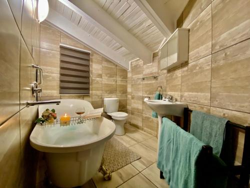 a bathroom with a tub and a toilet and a sink at Boomhuisie in Komatipoort