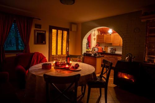 een woonkamer met een tafel en een keuken met een open haard bij Ladybird Lodge in Bela Crkva