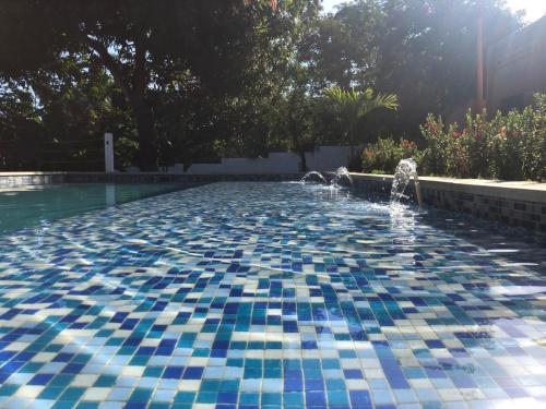 una piscina con una fuente en un patio en Color Hostel Palomino, en Palomino
