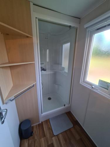 uma pequena casa de banho com um chuveiro e uma janela em Le verdoyant em Saint-Chéron
