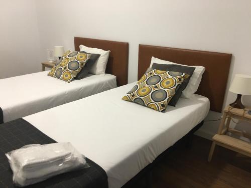 a hotel room with two beds and two nightstands at TMJ BeB in Porto