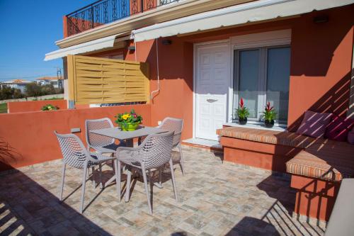 a patio with a table and chairs on a house at Paporas Apartments in Svoronata