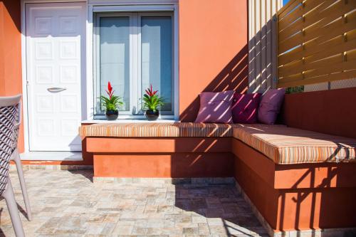 a bench on the side of a building with plants at Paporas Apartments in Svoronata
