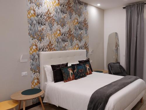 sypialnia z białym łóżkiem i tapetą w kwiaty w obiekcie LUSSUOSAMENTE Luxury B&B w mieście Caltanissetta
