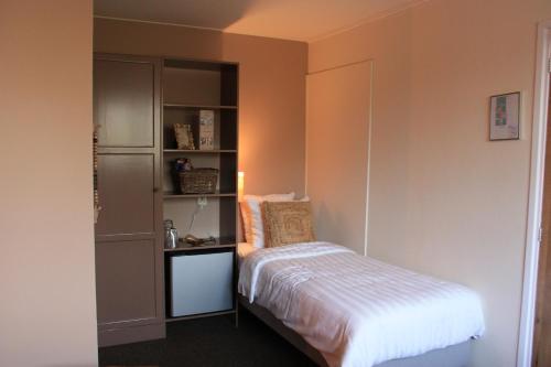 a bedroom with a bed and a book shelf at Maison Bellefleur B&B - Pension in Renesse