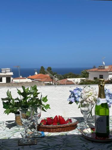 a table with a bottle of wine and a plate of strawberries at Casa Dionea, Puerto De La Cruz in Puerto de la Cruz