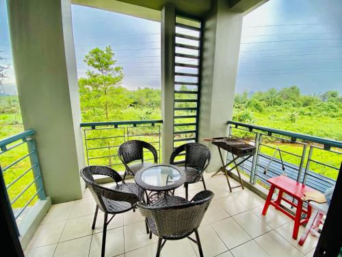 古晉的住宿－Faizal Madhi Homestay，阳台配有玻璃桌和椅子。