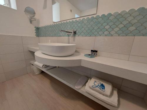y baño con lavabo y espejo. en Hotel Guarracino en Capri