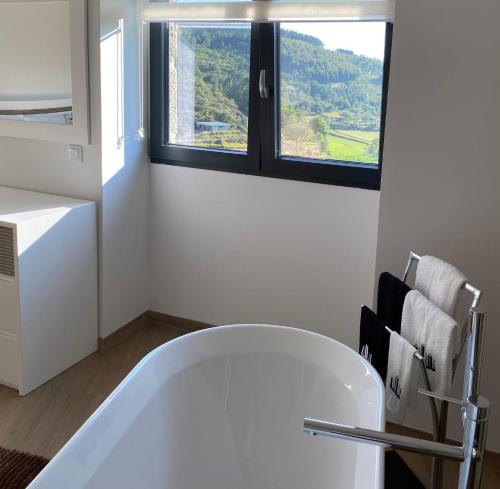 a white bath tub in a bathroom with a window at Casa da Carreira in Mondim de Basto