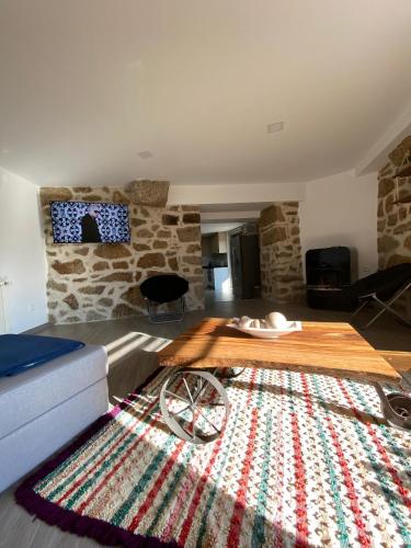 a living room with a wooden table on a rug at Casa da Carreira in Mondim de Basto