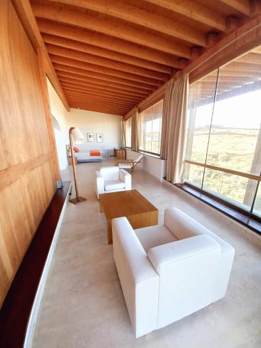 a living room with white furniture and a large window at Hotel Conventual de Alcántara in Alcántara