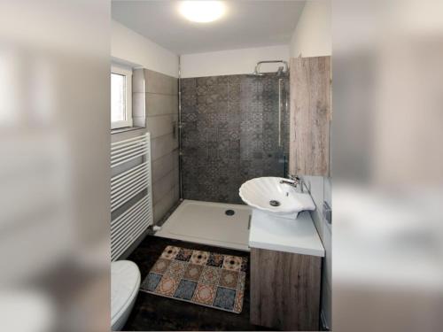 ein Badezimmer mit Waschbecken, Badewanne und Toilette in der Unterkunft Doppelhaushälfte Friesenglück mit Sauna in Dornumersiel